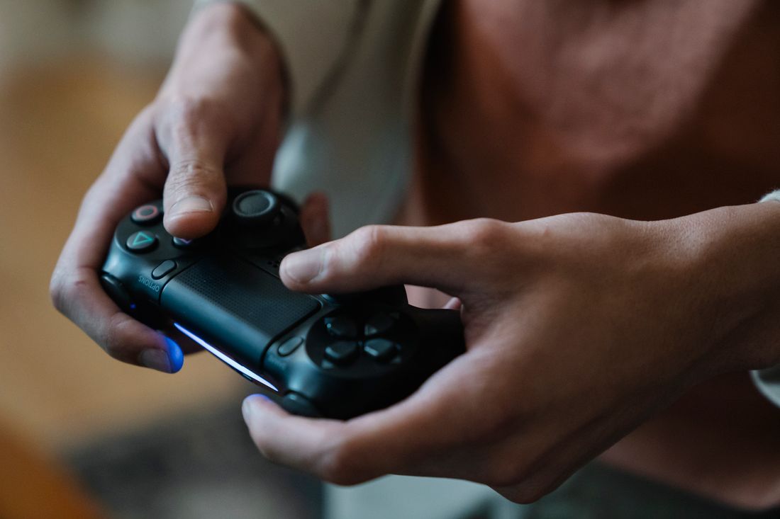 Hands holding a black game controller during a gaming session.